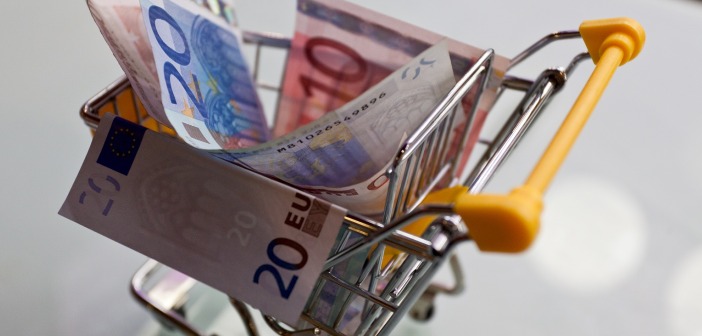 Mini shopping cart filled with Euro bills