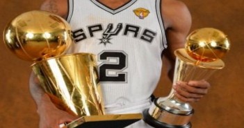 Kawhi Leonard holding two trophies